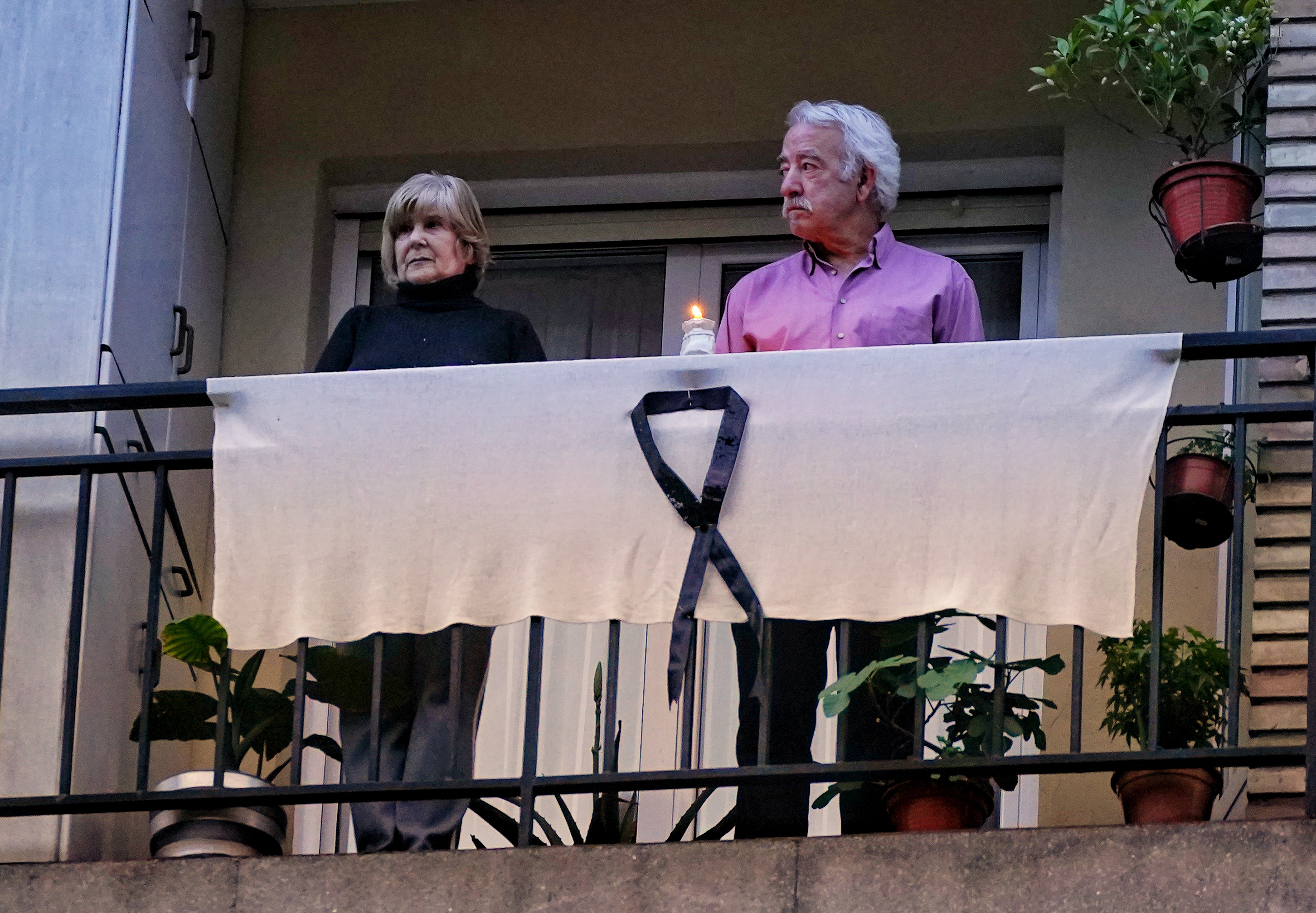 Two people leaning on their balcony to express their mourning and see the hologram